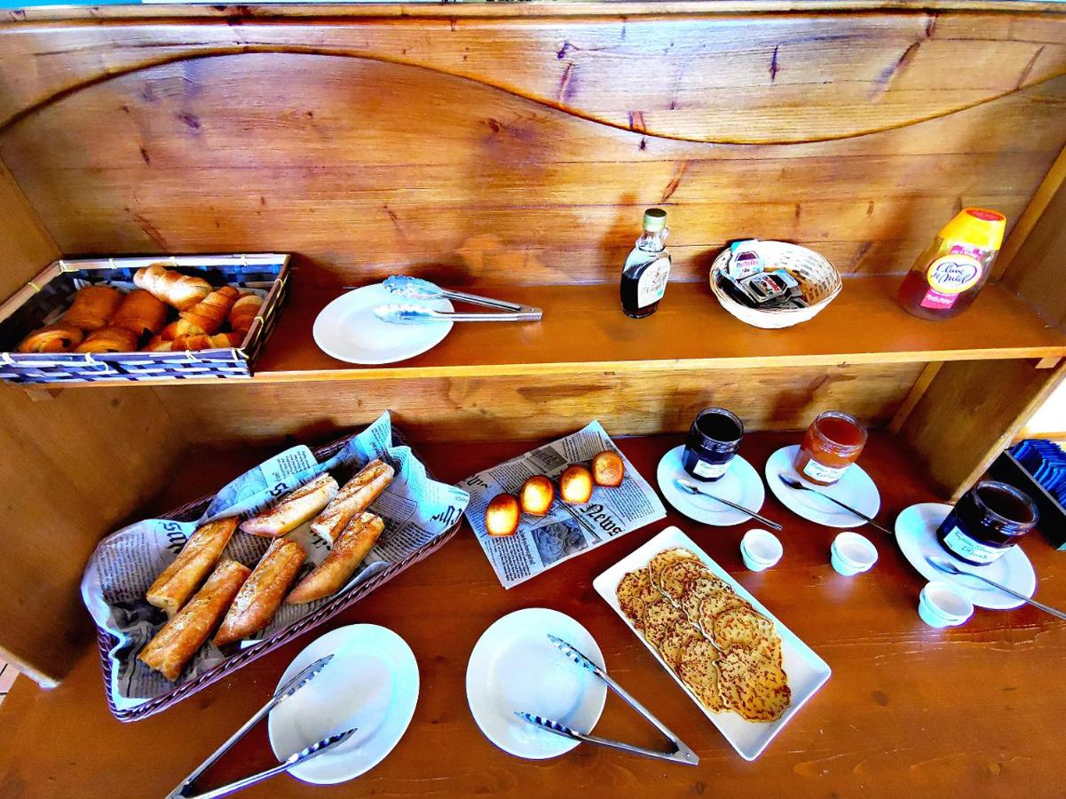 Salle de petit-déjeuner de l’hôtel Les Bruyères, buffet avec viennoiseries et boissons